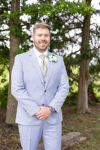 Load image into Gallery viewer, Man in a light blue suit standing outdoors with trees in the background