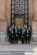 Load image into Gallery viewer, Group of men in formal attire standing on steps in front of a large building with a prominent entrance.