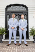 Load image into Gallery viewer, Two men in light blue suits standing in front of a black door with decorative glass panels.